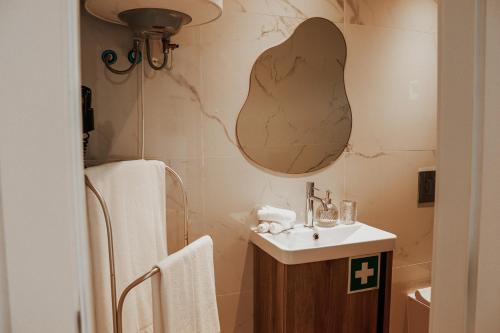 a bathroom with a sink and a mirror on the wall at Fish Village Apartments II in Vila Nova de Gaia