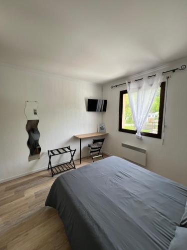 une chambre avec un lit, un bureau et une fenêtre dans l'établissement Complexe les 4 saisons, à Oust