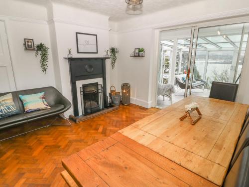 a living room with a table and a fireplace at Afallon in Menai Bridge