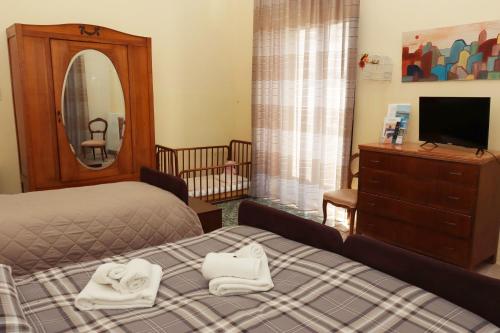 a bedroom with two towels on a bed and a mirror at Casa di Chiara in Crotone