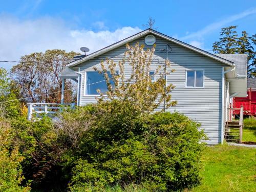 a gray house with a red house at Cliff Haven on the Bay in Alert Bay