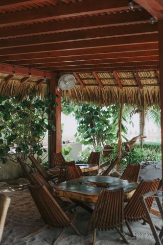 a patio with a table and chairs under a roof at El Origen Villas & Spa-Puerto Escondido in Puerto Escondido
