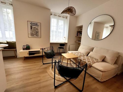 un salon avec un canapé et un miroir dans l'établissement Darbefeuille, grand studio centre ville 2 personnes, à Nantes