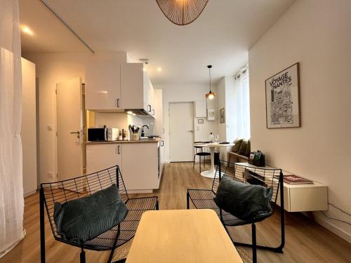 un salon avec une table et des chaises et une cuisine dans l'établissement Darbefeuille, grand studio centre ville 2 personnes, à Nantes