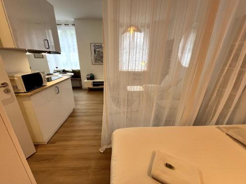 une chambre avec un lit et une cuisine avec un four micro-ondes dans l'établissement Darbefeuille, grand studio centre ville 2 personnes, à Nantes