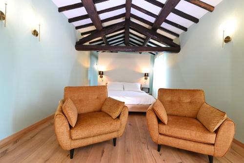 a bedroom with two chairs and a bed at Lodge dello Scoiattolo in Fosciandora