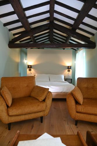 a bedroom with a bed and two chairs at Lodge dello Scoiattolo in Fosciandora