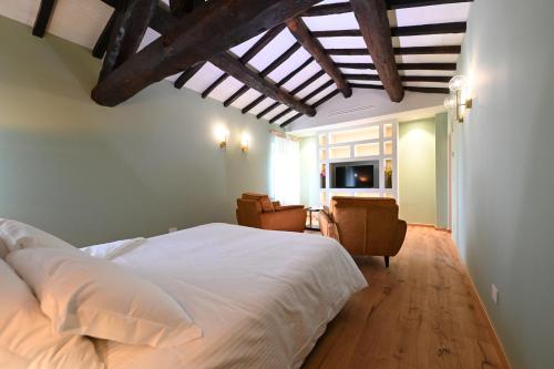 a bedroom with a white bed with a wooden ceiling at Lodge dello Scoiattolo in Fosciandora