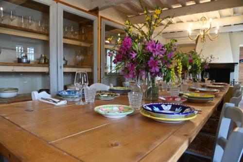 a long wooden table with plates and flowers on it at Lodge dello Scoiattolo in Fosciandora