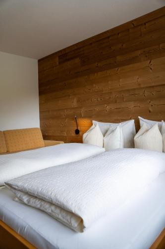 a bedroom with two beds with white blankets and pillows at Berghaus Schäfer in Faschina