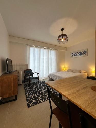 une chambre avec un lit et un bureau avec une télévision dans l'établissement Super appartement plein centre, à Aix-les-Bains