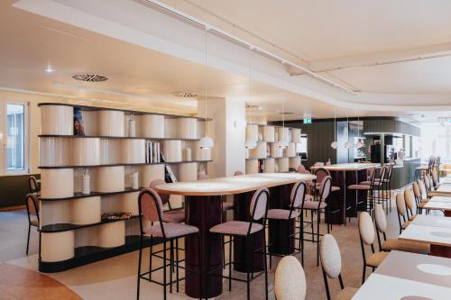 a restaurant with tables and chairs and shelves at Premier Inn Köln City Mediapark in Cologne