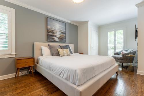 a white bedroom with a large bed and a chair at The Eloise by Stay Local Nashville in Nashville