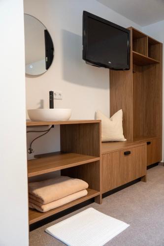 a bathroom with a vanity with a sink and a mirror at Berghaus Schäfer in Faschina