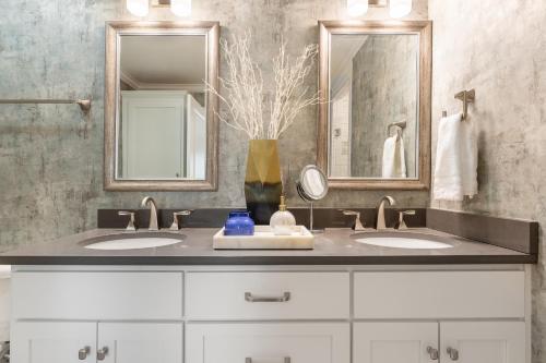 a bathroom with two sinks and two mirrors at The Eloise by Stay Local Nashville in Nashville