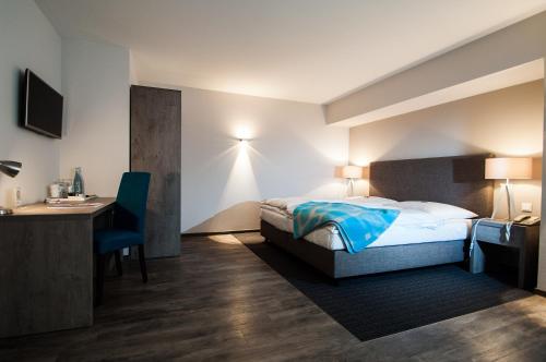 a hotel room with a bed and a desk and a desk at Hotel Alte Redaktion in Gevelsberg