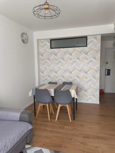 un salon avec une table, des chaises et un canapé dans l'établissement Petit appartement, à Lourdes