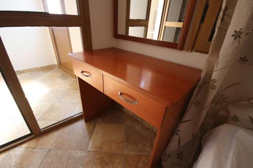 a wooden dresser in a room with a mirror at Vila Bajrami in Vlorë