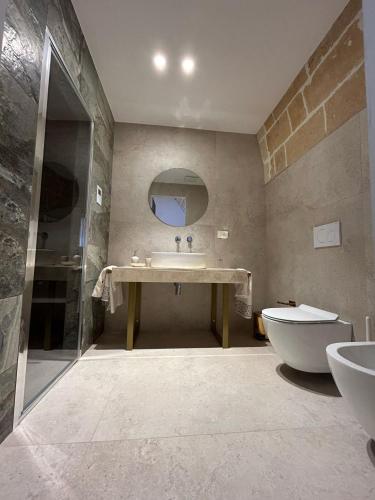 a bathroom with a sink and a tub and a toilet at MAGNIFICAT luxury rooms in Matera
