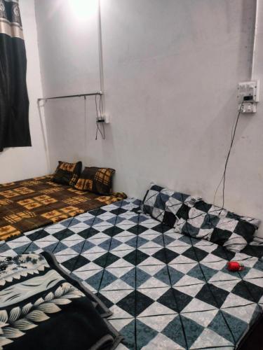 a bedroom with a checkered floor in a room at Mathura vrindavan Gokul Dham in Mathura
