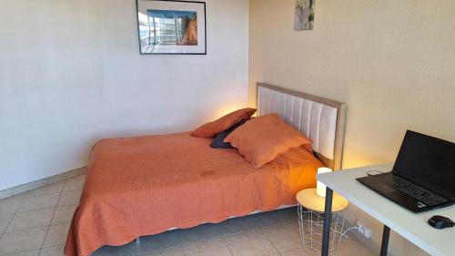 une chambre avec un lit et un bureau avec un ordinateur portable dans l'établissement Superbe T3 terrasse et vue mer - Islette du Riou - La Napoule, à Mandelieu-la-Napoule