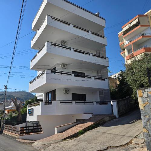 a building with balconies on the side of a street at Lazy Roo Hostel Saranda in Sarandë