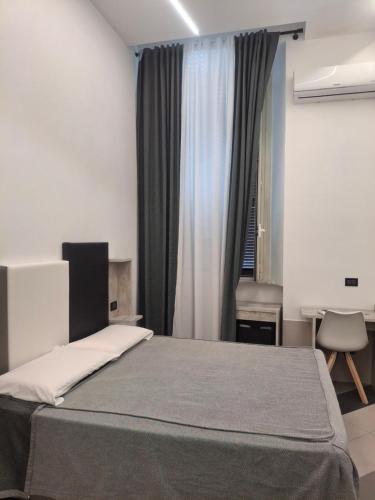 a bedroom with a bed and a desk and a window at Hotel Viennese in Rome