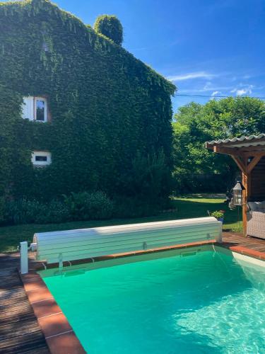 une piscine avec un banc à côté d'une maison dans l'établissement Namiel - Maison de vacances, Piscine, Loisirs, à Damiatte