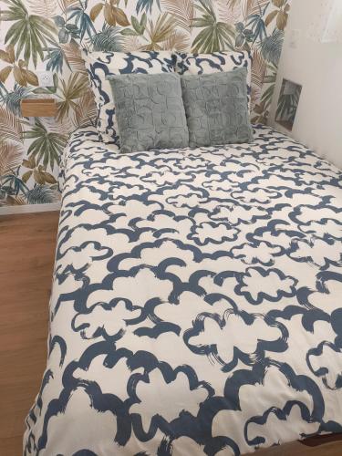 - un lit avec une couette et des oreillers en noir et blanc dans l'établissement Petit appartement, à Lourdes