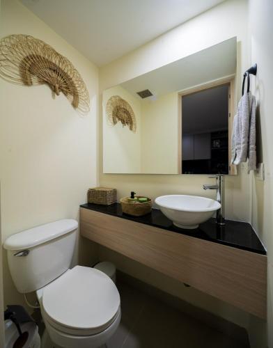 a bathroom with a white toilet and a sink at Private Terrace Duplex in El Poblado in Medellín