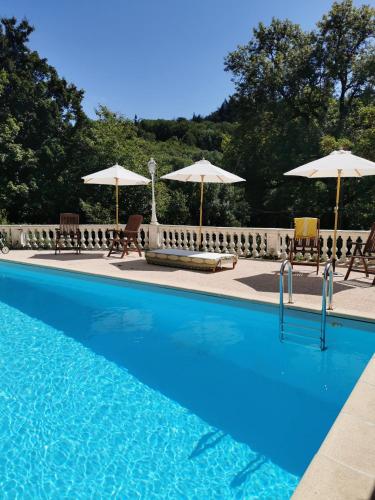 une piscine avec chaises et parasols dans l'établissement La manufacture royale de la bonde Chambre 2, à Cuxac-Cabardès