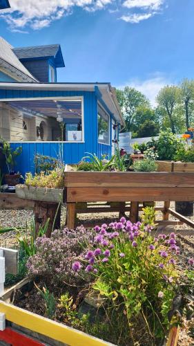 a wooden bench in a garden with flowers at la petite maison en bois bleue in Quiberville