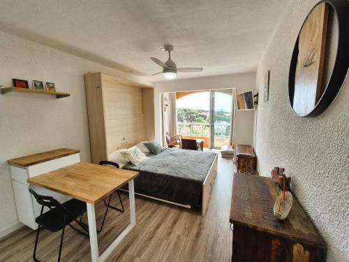 une chambre avec un lit et une table dans une pièce dans l'établissement Studio refait à neuf, vue mer, proche des plages et des commerces..., à Saint-Mandrier-sur-Mer