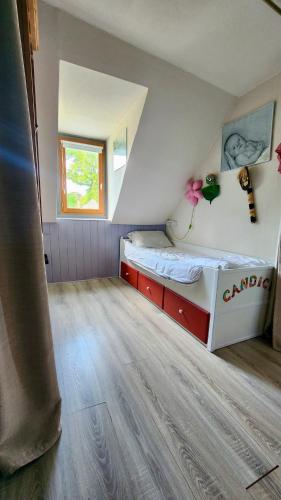 a small room with a bed and a window at la petite maison en bois bleue in Quiberville