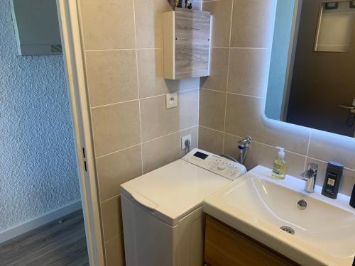 une salle de bain avec un lavabo et une machine à laver dans l'établissement Studio refait à neuf, vue mer, proche des plages et des commerces..., à Saint-Mandrier-sur-Mer