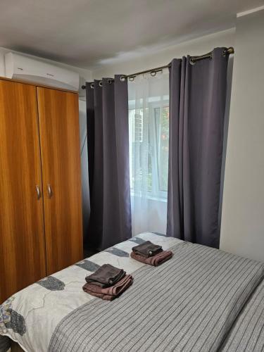 a bedroom with a bed with two towels on it at La Bloc in Băile Herculane