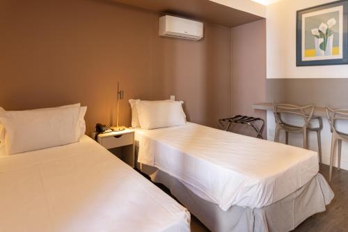 Un ou plusieurs lits dans un hébergement de l'établissement Savassi Hotel