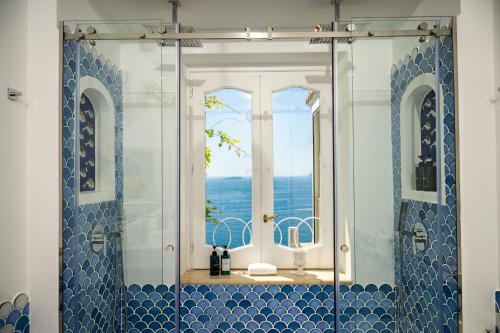 a bathroom with a shower with a view of the ocean at Villa Santa Chiara Positano Suites in Positano