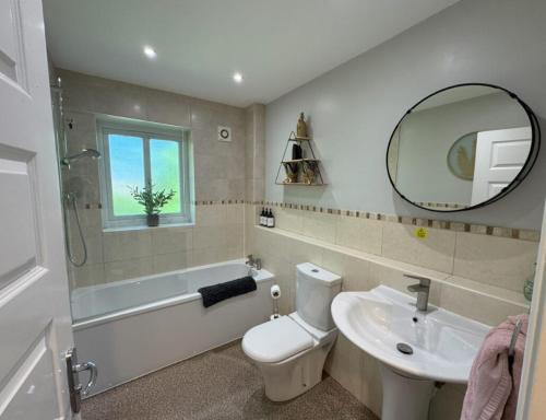 a bathroom with a sink and a toilet and a mirror at Stylish 5BR Townhouse in Manor