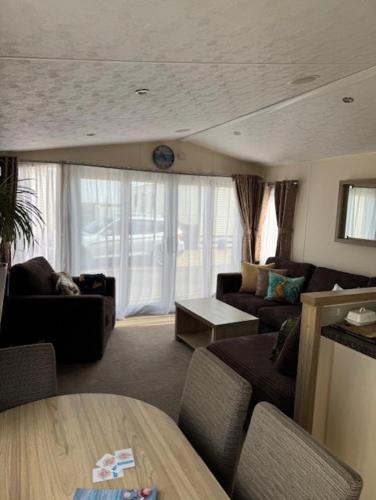a living room with a couch and a table at Static Caravan on the Jurassic Coast at Freshwater Beach Holiday Park in Burton Bradstock