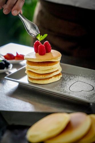 a stack of pancakes with strawberries on top on a tray at Hotel Maria Serena in Rimini