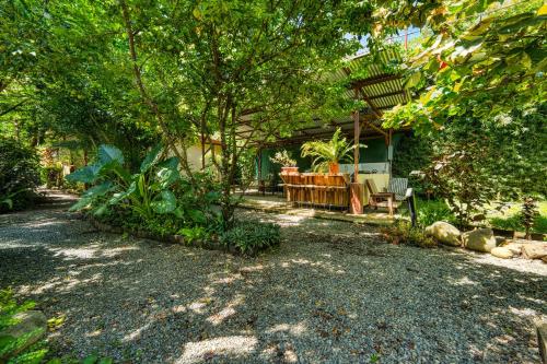 a yard with a house with a tree and a patio at Bamboo River House and Hotel in Dominical