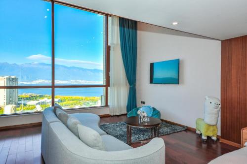 a living room with a couch and a large window at 大理顾里海景别墅Dali Guli Sea View Villa Hotel in Dali
