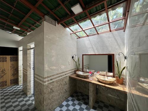une salle de bain avec deux lavabos et un grand miroir dans l'établissement Mon's House, à Cư Chinh
