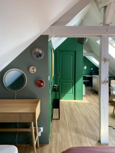 Cette chambre dispose d'une porte verte et d'un miroir. dans l'établissement Les Lotus de BELLE-YLE, à Yvré-lʼÉvêque