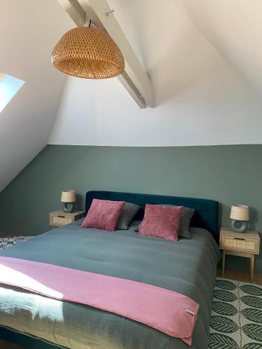 - une chambre avec un lit bleu et 2 oreillers roses dans l'établissement Les Lotus de BELLE-YLE, à Yvré-lʼÉvêque