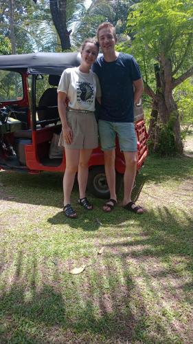 a man and a woman standing in front of a car at Jungle Eco Lodge & Safari in Sigiriya