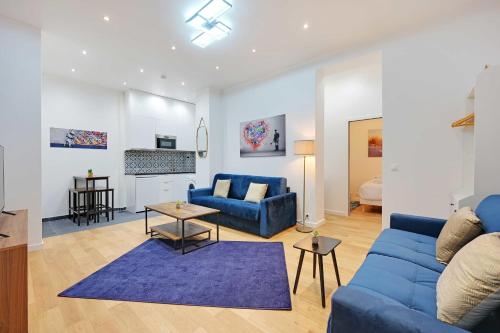 un salon avec un canapé bleu et une table dans l'établissement Appartement cosy à deux pas de République, à Paris
