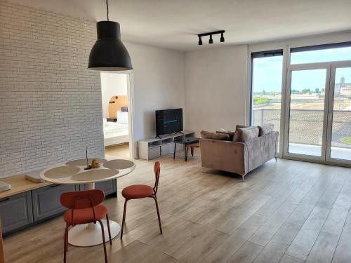 Una sala de estar con un sofá, una mesa y sillas. en Sika Platinum Premium Apartment- private parking, en Arad