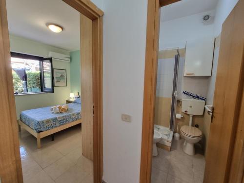 a bathroom with a bed and a toilet in a room at Respiro di Mare by Holiday World in Buonfornello